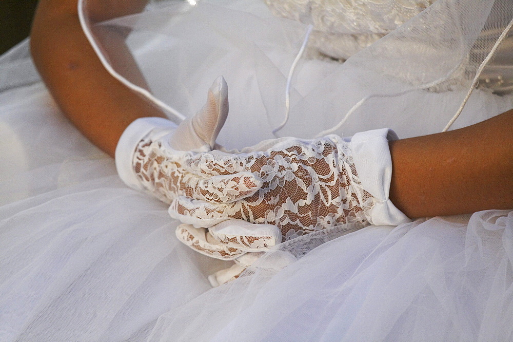 Guatemala catholic first communion and mass at remate, el peten. close-up of girls hands wearing lace gloves