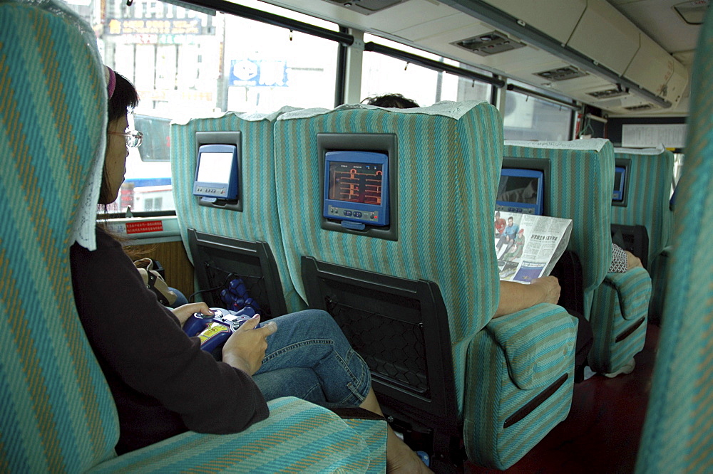 Transport, taiwan. Interior of inter-city bus, with video game and movie screens ay each seat