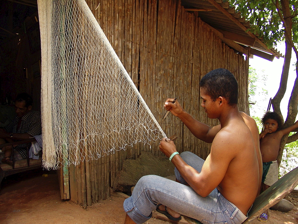 Colombia fisherman repairing his nets at a small village near barrancabermeja on the rio magdalena