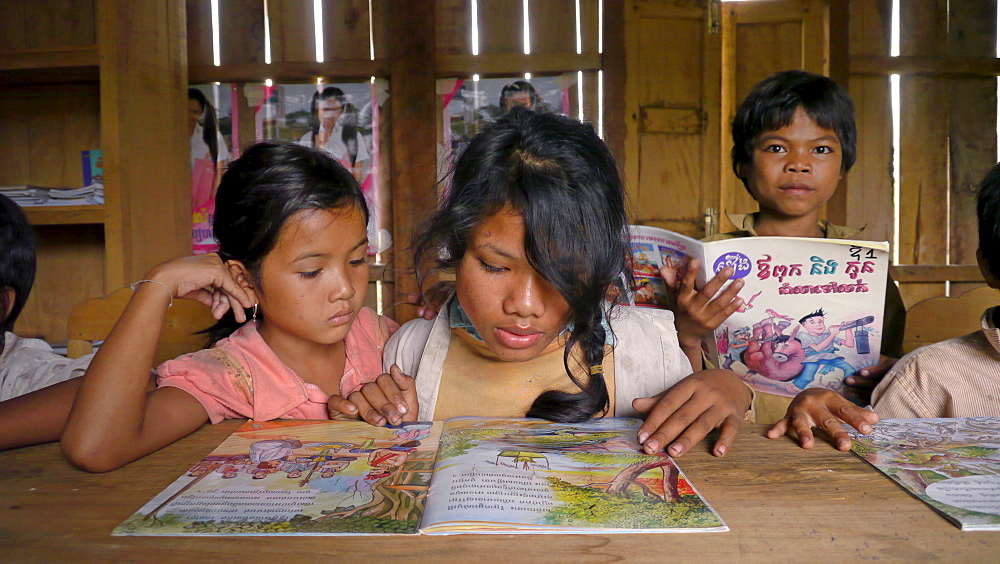 CAMBODIA Katot village, inhabited by the Prov tribal group, Stung Treng district. Library and literacy building provided by DPA and SCIAF. Children reading books