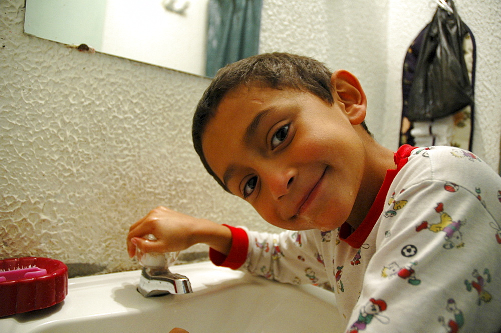 Colombia day in the life series: hugo andres, 7, of ciudad bolivar, bogota, brushing his teeth.