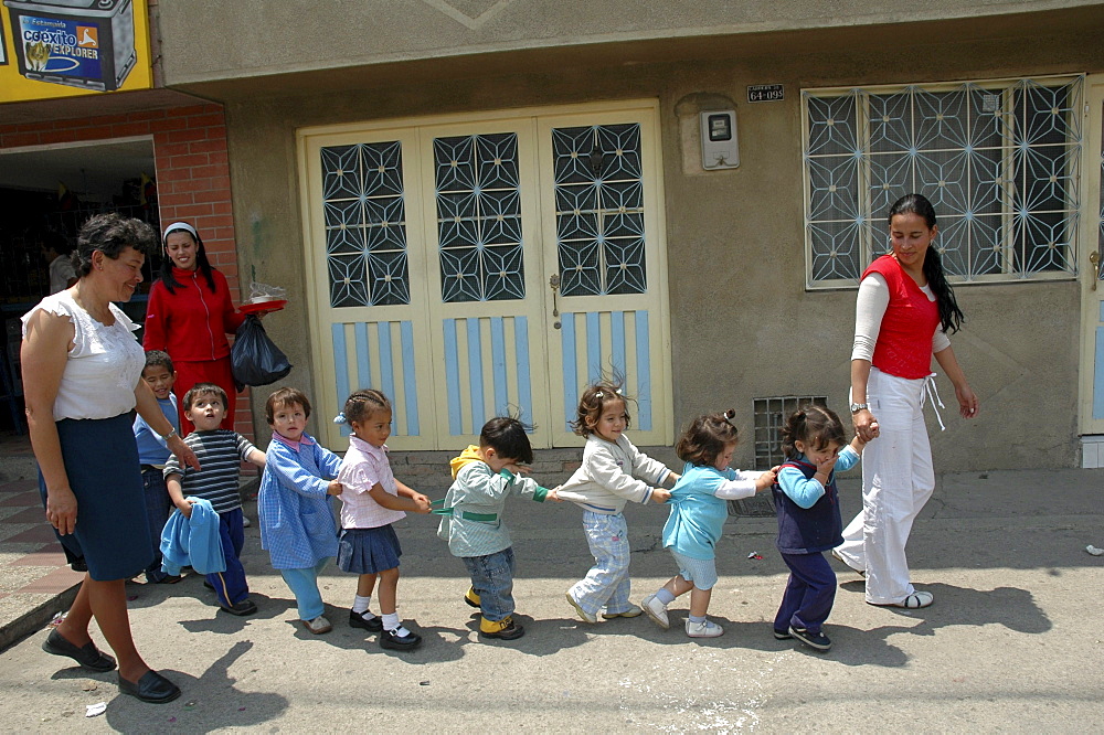 Colombia children in crocodile formation walking to their day care center, ciudad bolivar, bogota,