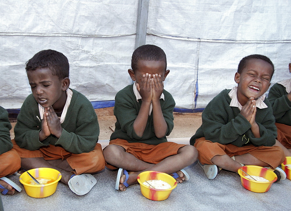 Ethiopia children praying and eating lunch at the bethlehem centre pre school and day care, addis ababa