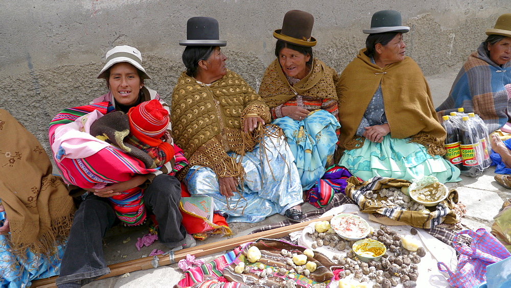 BOLIVIA Street scenes in Achacachi. Aymara women gathered to eat meal on street during festival