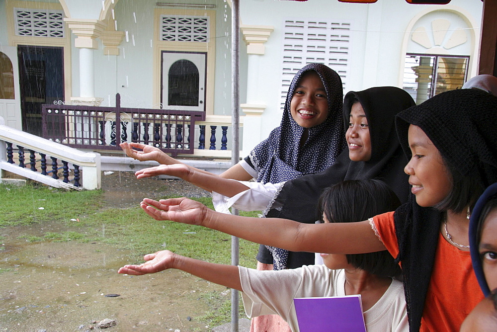 Thailand muslim girls catching raindrops. Pattani