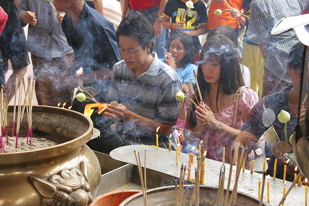 Thailand devotees praying and lighting incense. Ancient buddhist temple and stupa of phra pathom chedi, nakhon pathom