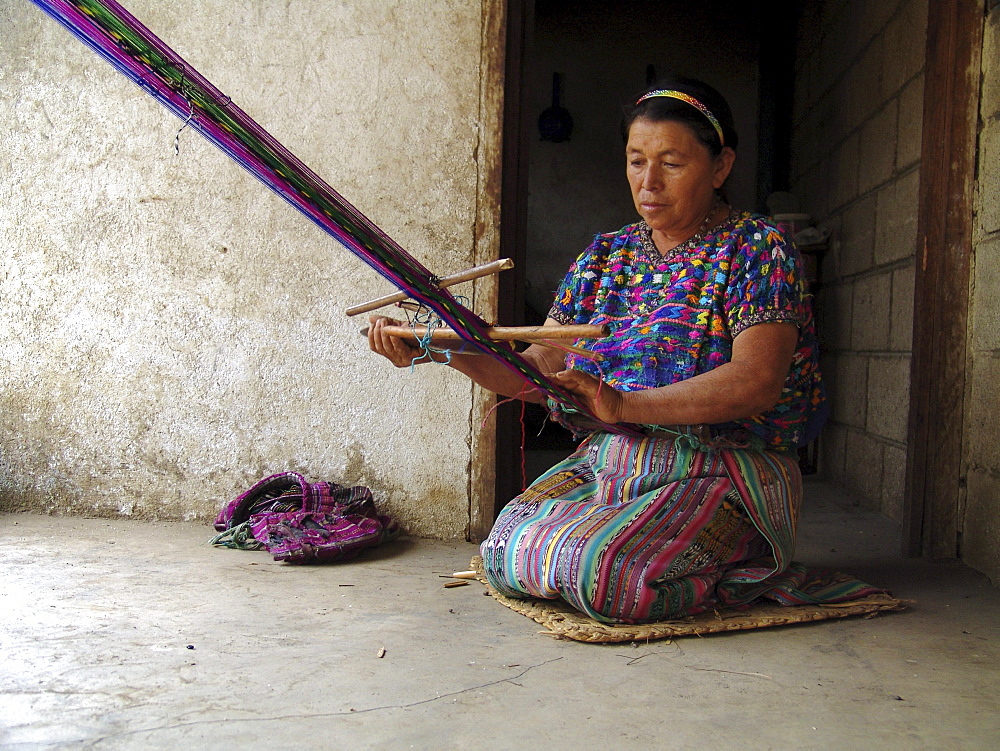 Guatemala mayan woman weaving with a back strap loom, tsantepey