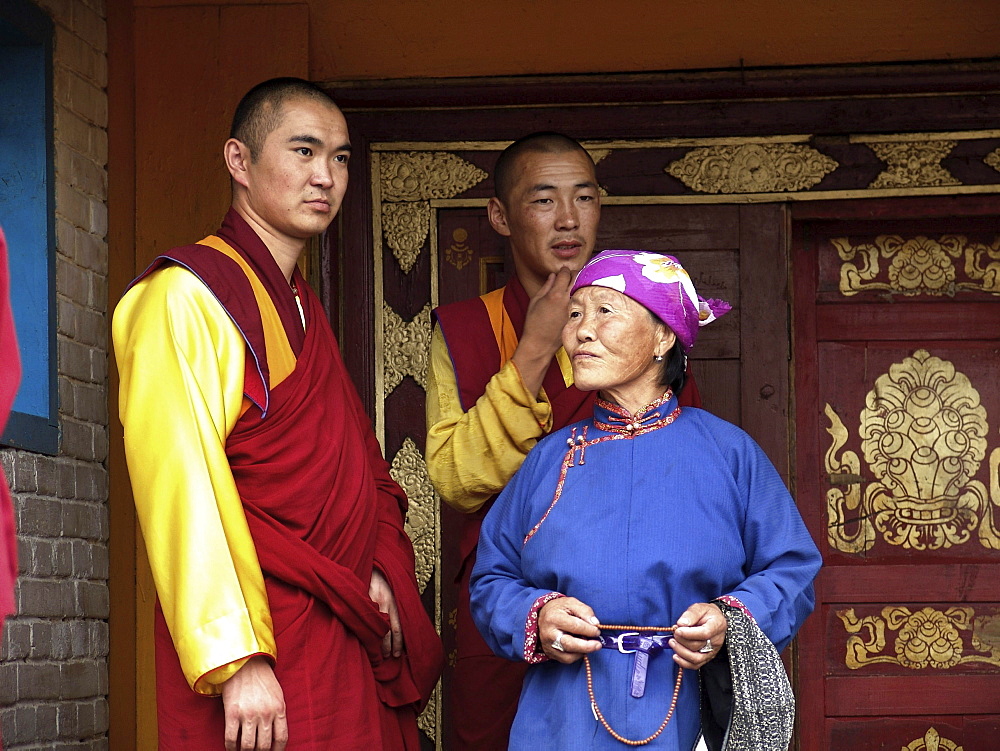 Mongolia woman and buddhist monks at gandan monastery, ulaan baatur. Main gate