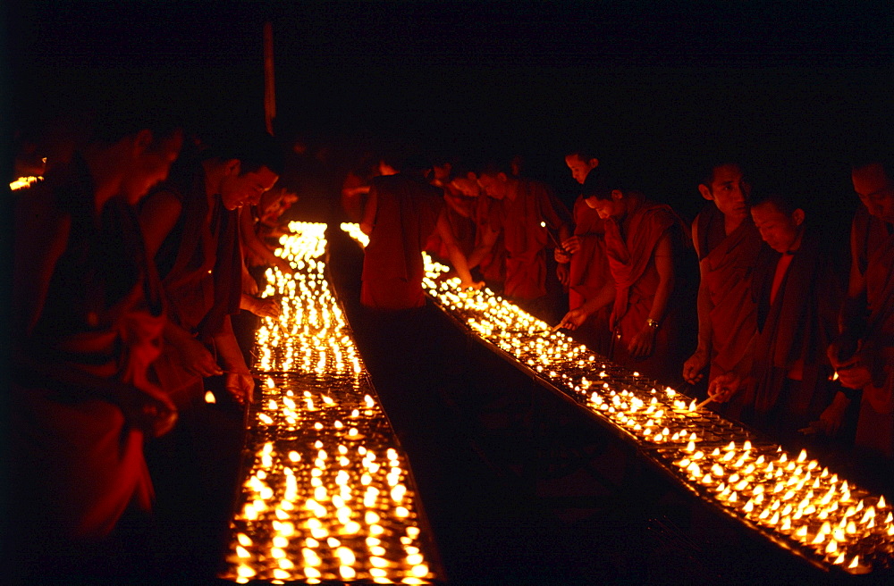 Monks offer butter lamps. Bodgaya, india. Monks offer butter lamps in front of mahabodhi temple marks site of buddhas enlightment twenty-five hundred years. centuries have made pilgrimages across himalayas to sites connected with life of historical buddha. From a tantric perspective, pilgrimage is more than paying homage at sacred sites. Rather, it is that activities performed at these places become a memory of place itself. By attuning oneself through ritual meditation to this timeless presence, similar experiences be evoked