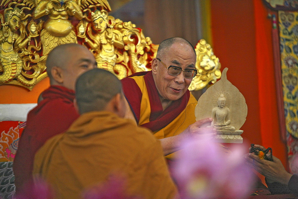 Hh the 14th dalai lama holds a statue of buddha with bodhi-tree-leaf. Kalachakra initiation in bodhgaya, india  