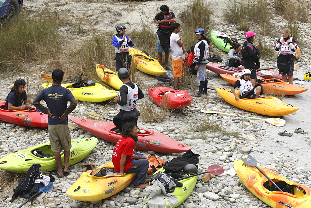 Paddlers carry their kayak to the start point for Downriver challenge. Trisuli, Nepal