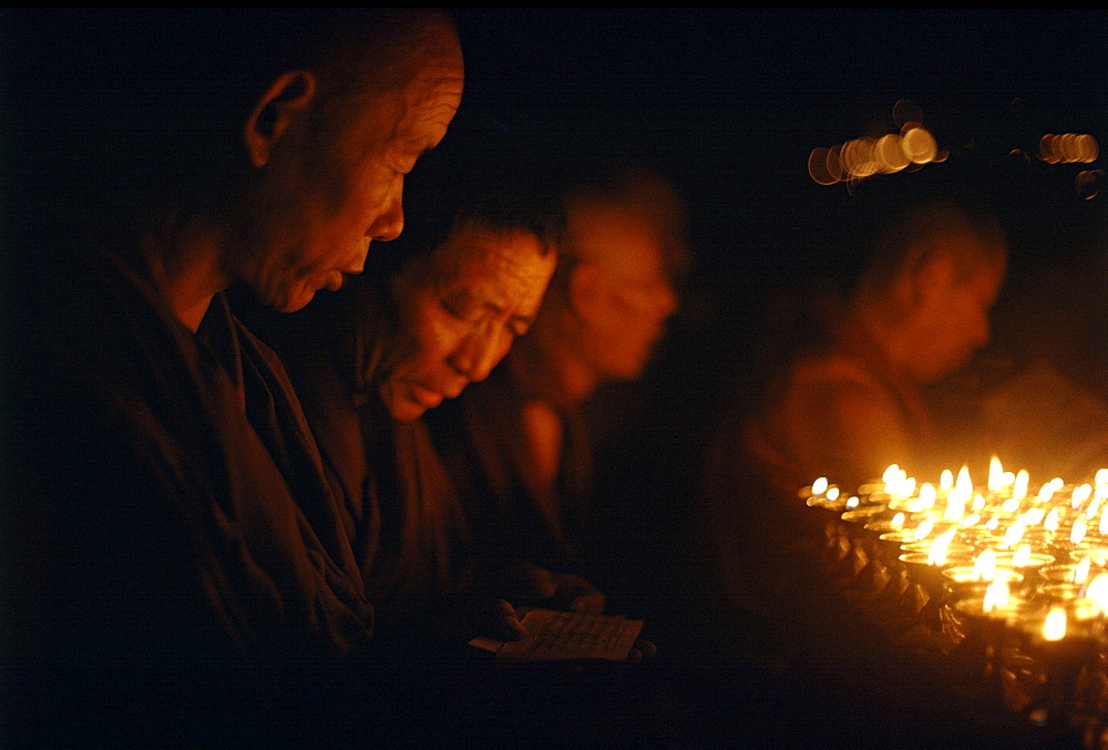 Monks offer butter lamps. Kalachakra initiation, bodhgaya. India. Monks attending kalachakra initiation at mahaboudhi temple in bodhgaya, india. mahabodhi temple marks site of buddhas enlightment twenty-five hundred years. centuries have made pilgrimages across himalayas to sites connected with life of historical buddha. From a tantric perspective, pilgrimage is more than paying homage at sacred sites. Rather, it is that activities performed at these places become a memory of place itself. By attuning oneself through ritual meditation to this timeless presence, similar experiences be evoked