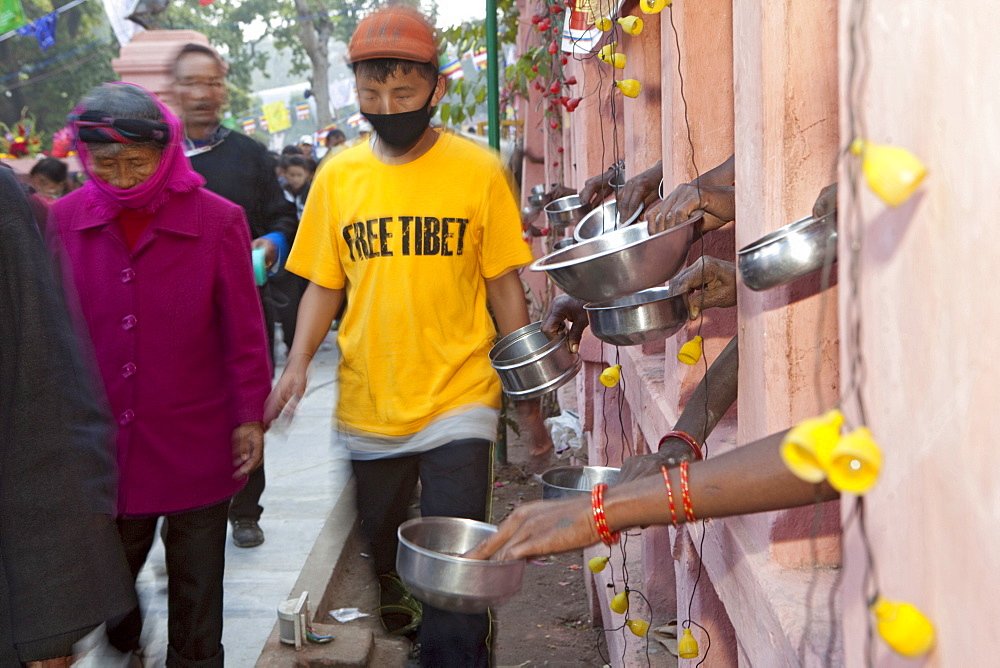 While circumambulating maha bodhi temple, tibetans making money offerings to bihari in need. Kalachakra initiation in bodhgaya, india  