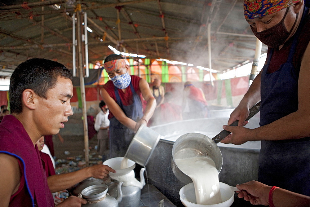 Volunteer monks make tibetan butter salt milk tea in gigantic vessel for the kalachakra initiation attendants. Kalachakra initiation in bodhgaya, india  