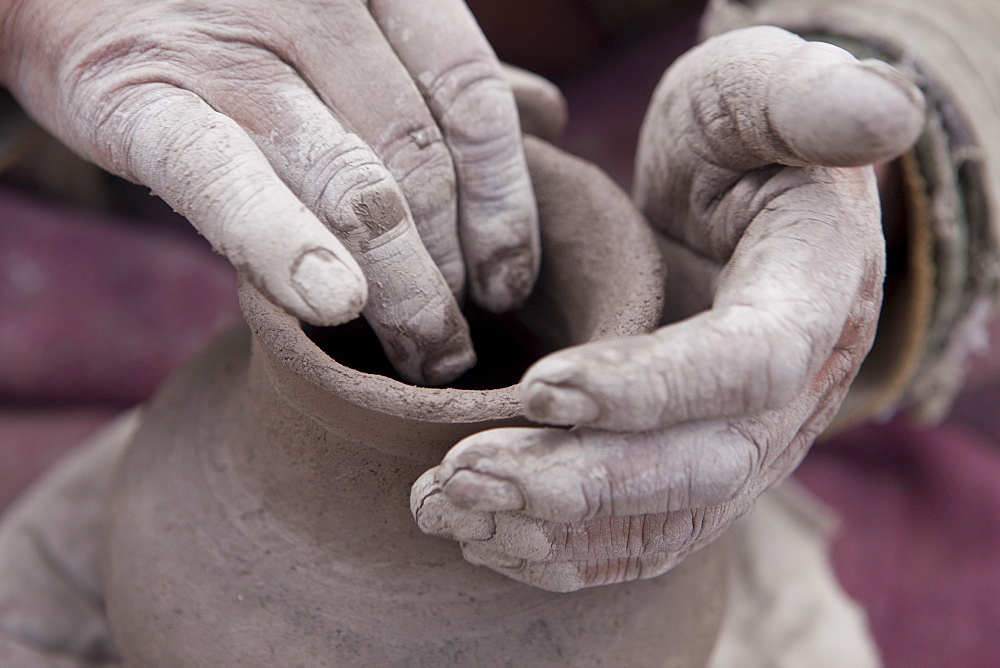 Skalzang Norbu, 69, handbuilds a bumpa, or ritual vase that may be placed within a lukang or foundation of a house. Ladakh, India