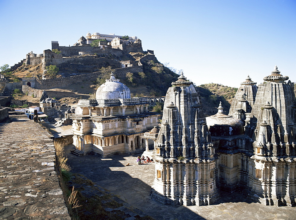 Temples in the foreground with the Badal Mahal (Cloud Palace) on hilltop, Kumbalgarh Fort, Rajasthan state, India, Asia