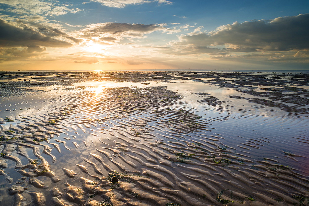 View of sandy beach and pools at low tide, at sunset, Reculver, Kent, England, United Kingdom, Europe