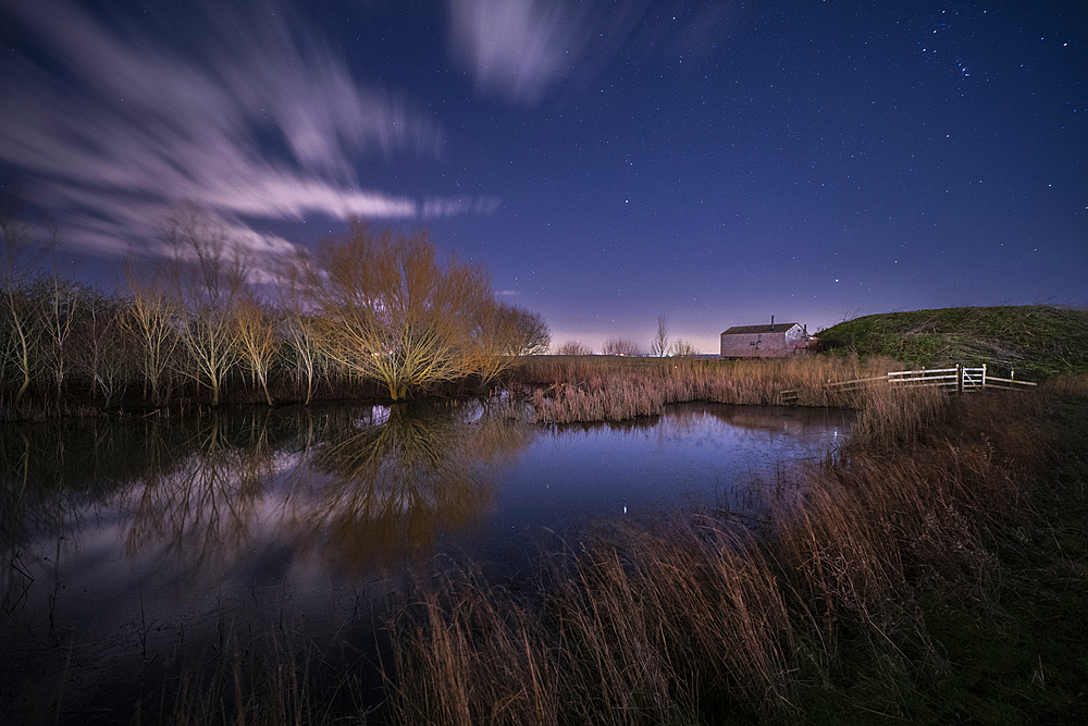 Shepherd Hut and pond at night illuminated by moonlight, Elmley Nature Reserve, Kent, England, United Kingdom, Europe