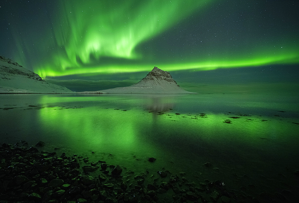 Aurora borealis (Northern Lights) over Kirkjufell Mountain (Wizard's Hat) reflected in ocean, Iceland, Polar Regions