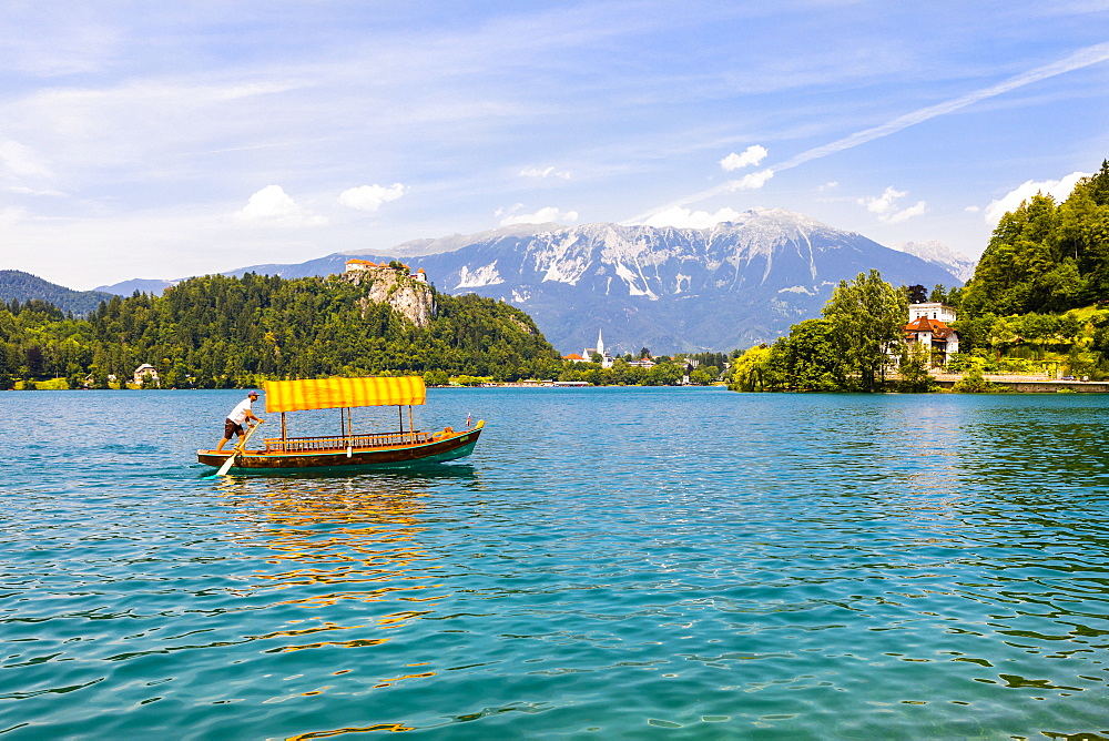 A boat in Lake Bled with Bled Castle in the background, Slovenia, Europe