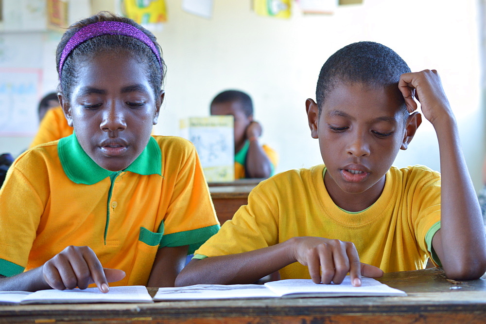 Two grade 3 students reading at Kusbau School in the coastal region of Madang in Papua New Guinea, Pacific