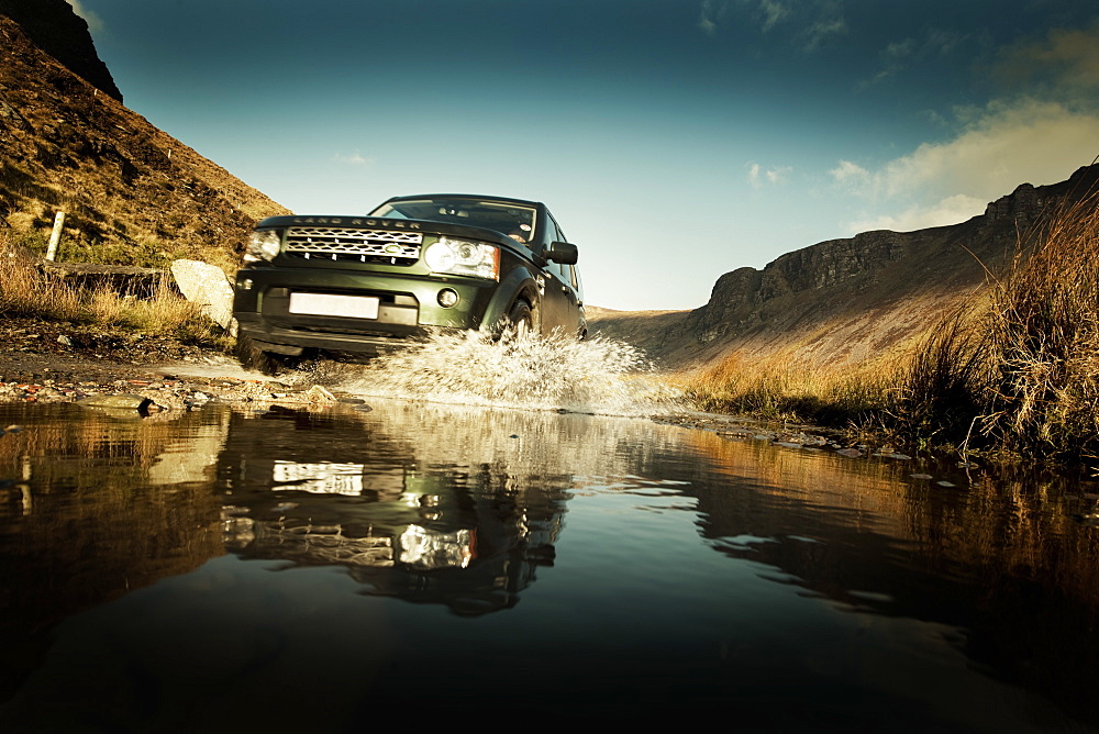 Land Rover splashing through a flooded track, Republic of Ireland, Europe