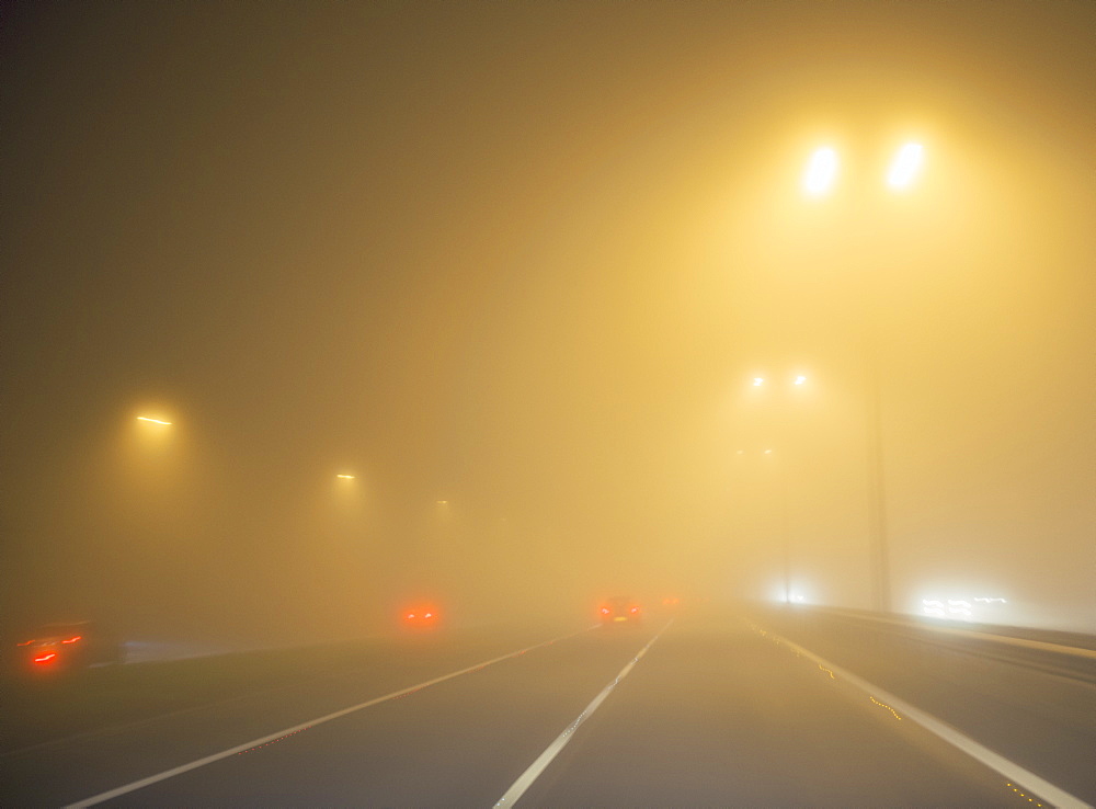 Motorway traffic in thick fog at night, United Kingdom, Europe