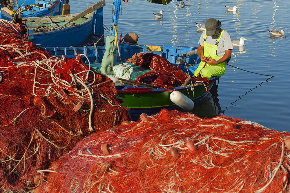 Fisherman mending nets, Alghero, Sardinia, Europe