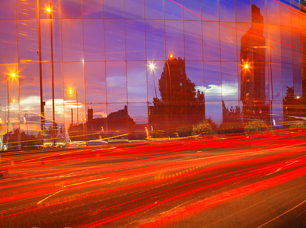 Car tail lights streaming past mirrored building, Liverpool, Merseyside, England, United Kingdom, Europe