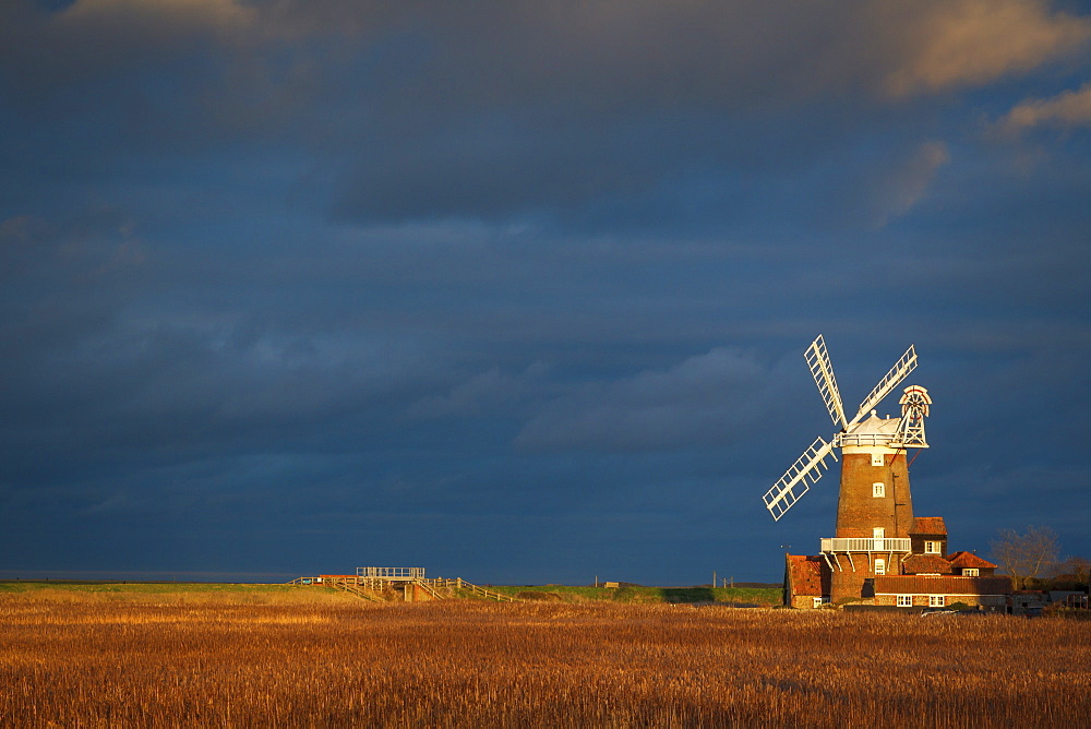 Storm clouds move in over the reedbeds towards Cley Windmill at Cley Next the Sea, Norfolk, England, United Kingdom, Europe