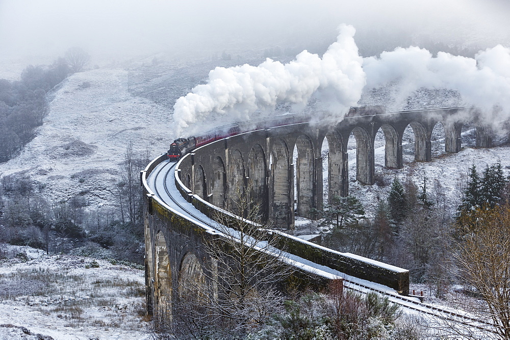 A wintery scene of the Glenfinnan Railway Viaduct with steam locomotive, Highlands, Scotland, United Kingdom, Europe