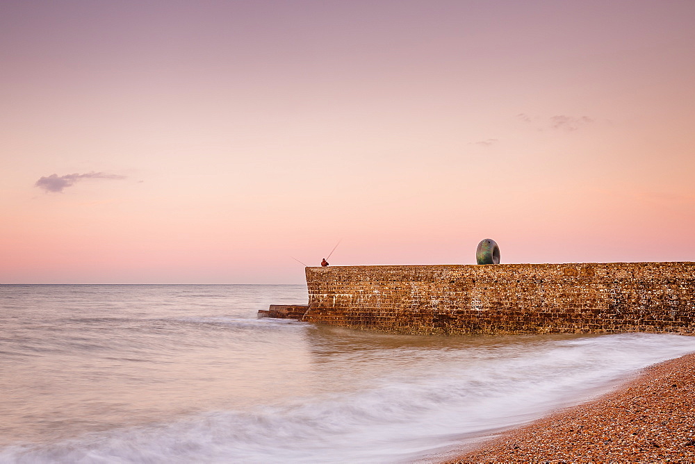 Fisherman and the Green Doughnut sculpture at dawn on Brighton Seafront, Brighton, East Sussex, England, United Kingdom, Europe