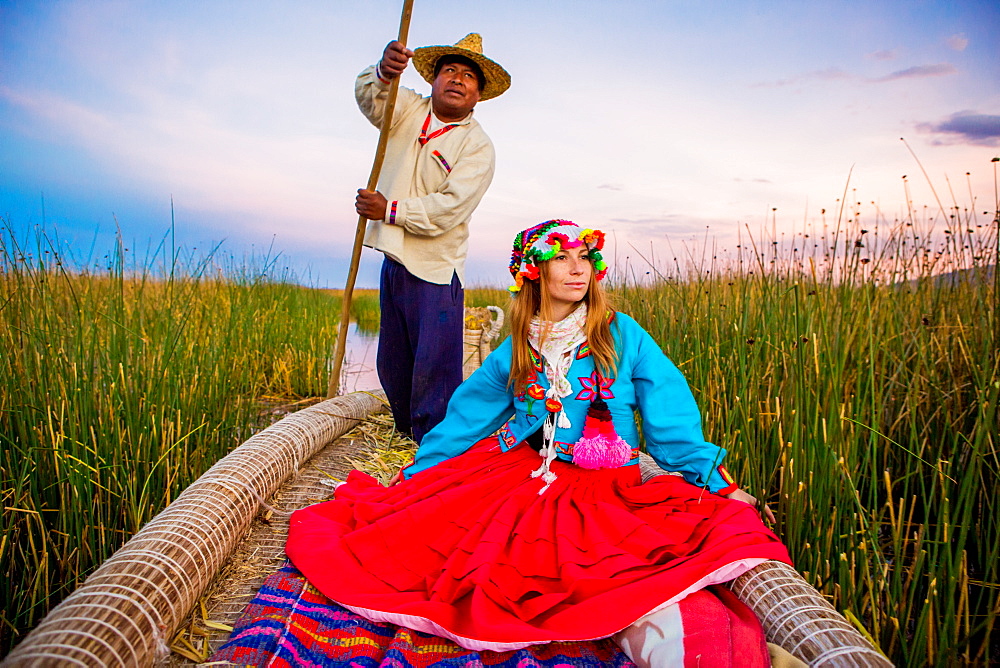 Girl on grass boat with Quechua Indian rower, Floating Grass islands of Uros, Lake Titicaca, Peru, South America