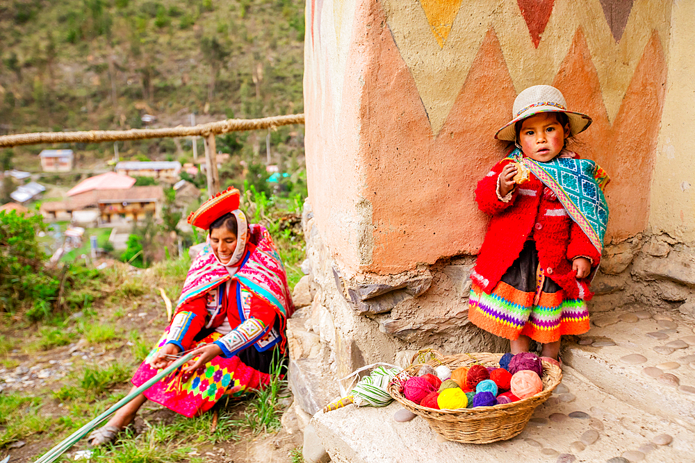 Quechua woman and child with snack, Ollantaytambo, Peru, South America