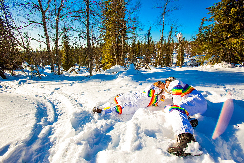 Couple kissing in matching Rainbow Ski Suits, Kakslauttanen Igloo West Village, Saariselka, Finland, Scandinavia, Europe