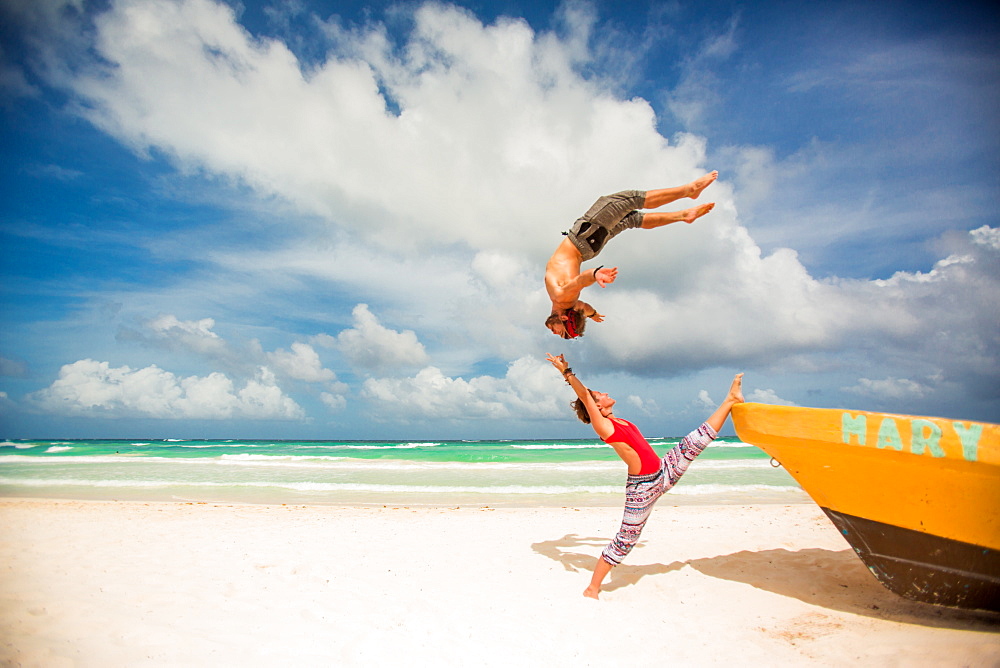 Acrobatic couple balancing together on the beach of Tulum, Mexico, North America