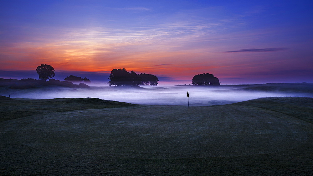 Dawn sky extending beyond the mist low lying in the sunken fairways of Delamere Forest Golf Club on a spring morning, Cheshire, England, United Kingdom, Europe