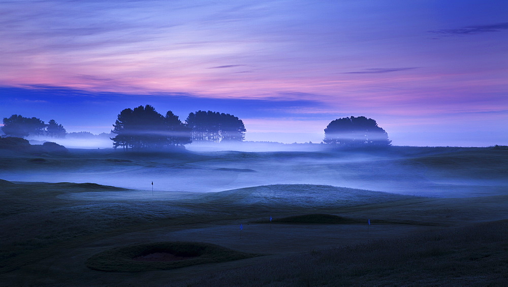 Spring mist lies in the cold undulating valleys across the greens and fairways at Delamere Forest Golf Club, Cheshire, England, United Kingdom, Europe