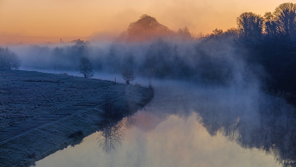 Winter dawn along the River Weaver with mist lingering among the trees and fields, Cheshire, England, United Kingdom, Europe