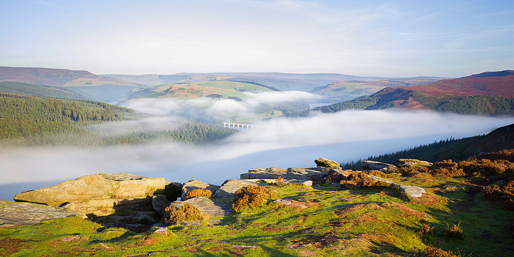 Early morning fog lingering above the Ladybower Reservoir in the valley below Bamford Edge, Peak District, Derbyshire, England, United Kingdom, Europe