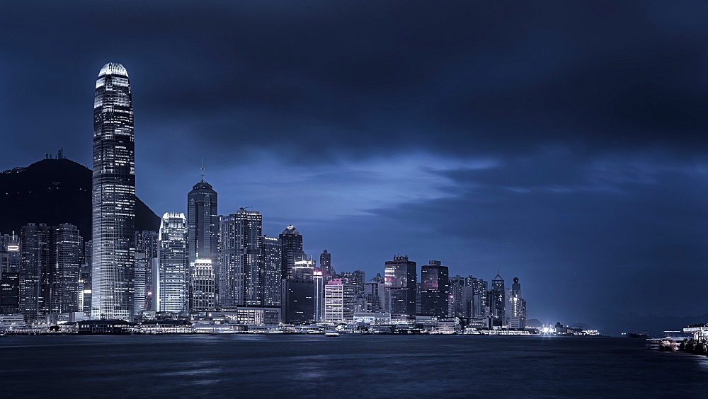 Looking across Victoria Harbour to the skyscrapers on Hong Kong Island with Victoria Peak beyond at night, Hong Kong, China, Asia