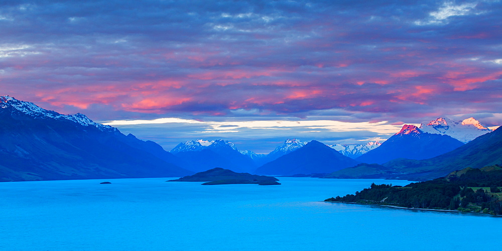 Mount Earnslaw and neighbouring mountain peaks in the Southern Alps are lit with the last rays of the sun beyond Lake Wakatipu, Otago, South Island, New Zealand, Pacific