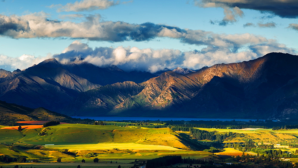 The plains and lakes of Otago region framed by cloud capped mountains, Otago, South Island, New Zealand, Pacific