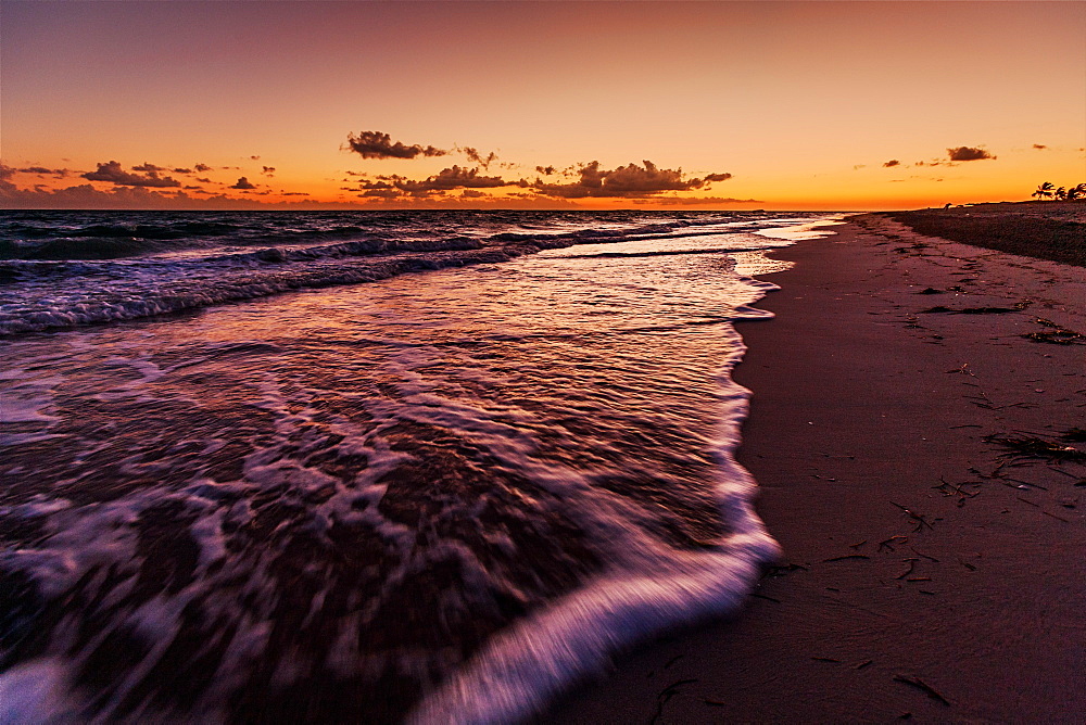 Waves roll onto the beach as dawn breaks beyond the Hicacos peninsula and long stretch of beach at Varadero, Cuba, West Indies, Caribbean, Central America