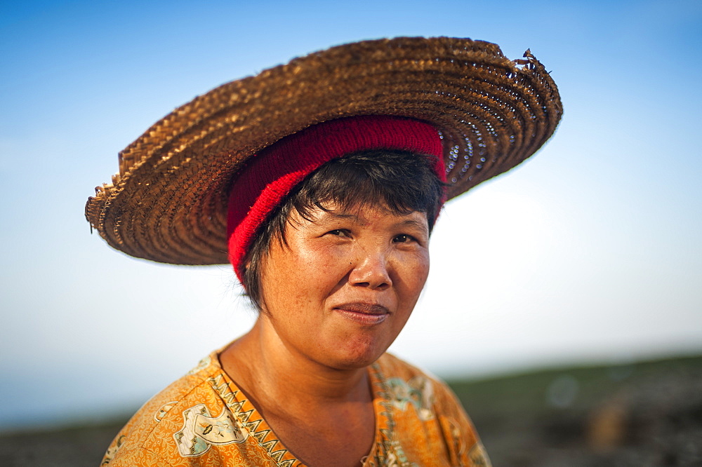 A Burmese woman panning for gold in a small stream near Putao stops to have her portrait taken, Kachin State, Myanmar (Burma), Asia