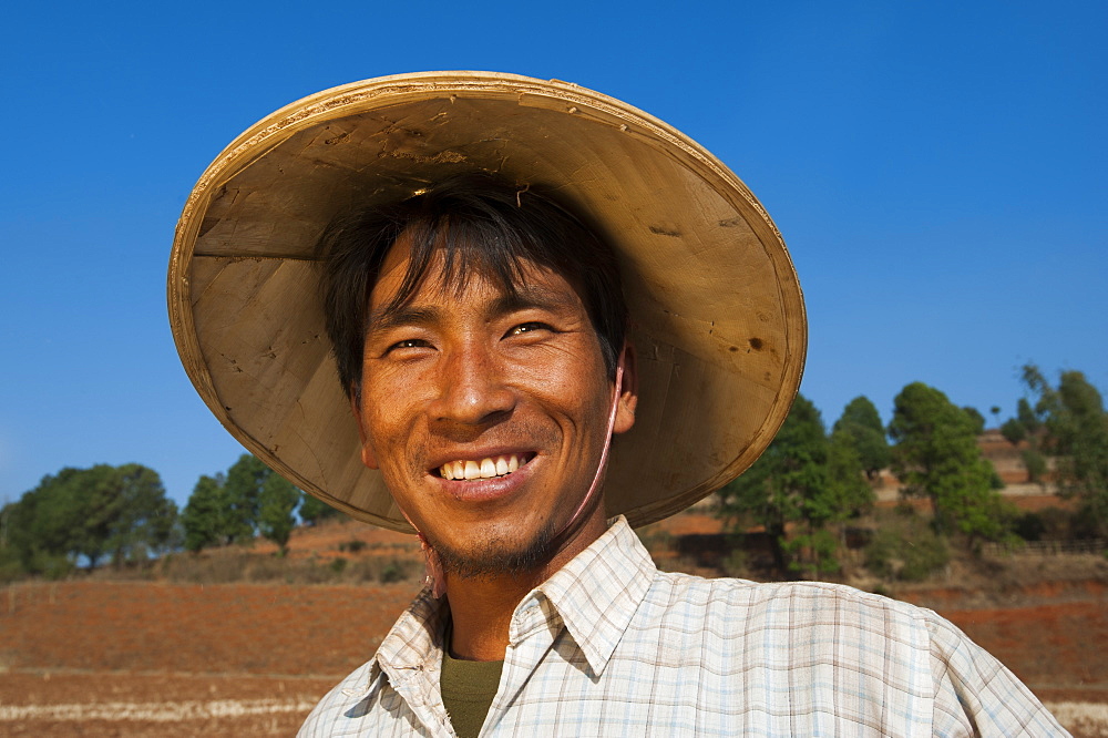 A man takes a short break from harvesting wheat to smile for the camera, Shan State, Myanmar (Burma), Asia