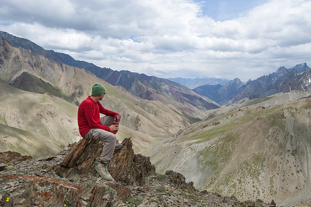 A trekker stops to admire the views from the top of the Konze La in the remote Himalayan region of Ladakh in northern India, India, Asia