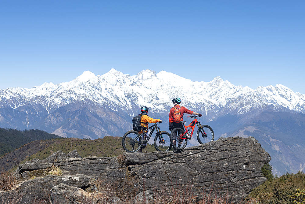 Mountain biking in the Himalayas with views of the Langtang mountain range in the distance, Nepal, Asia