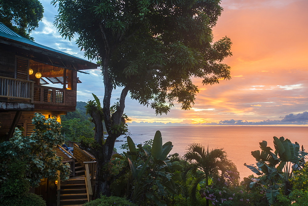 A tree house style apartment in the rainforest faces out to sea at sunset in Castara Bay in Tobago, Trinidad and Tobago, West Indies, Caribbean, Central America