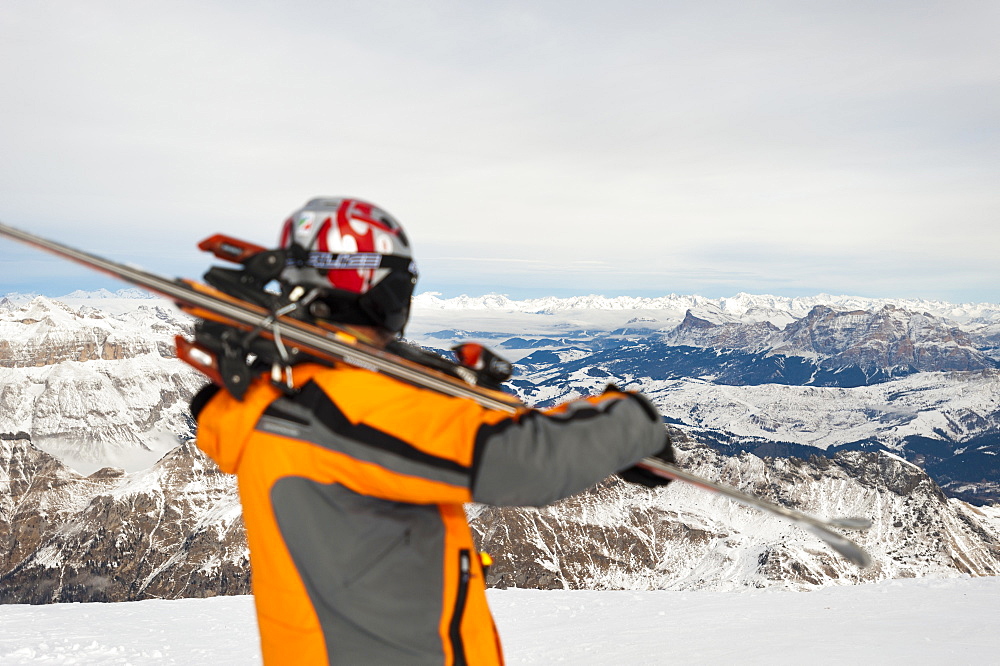 A skier prepares to ski down from the top of Marmolada in the Dolomite mountains, Italy, Europe